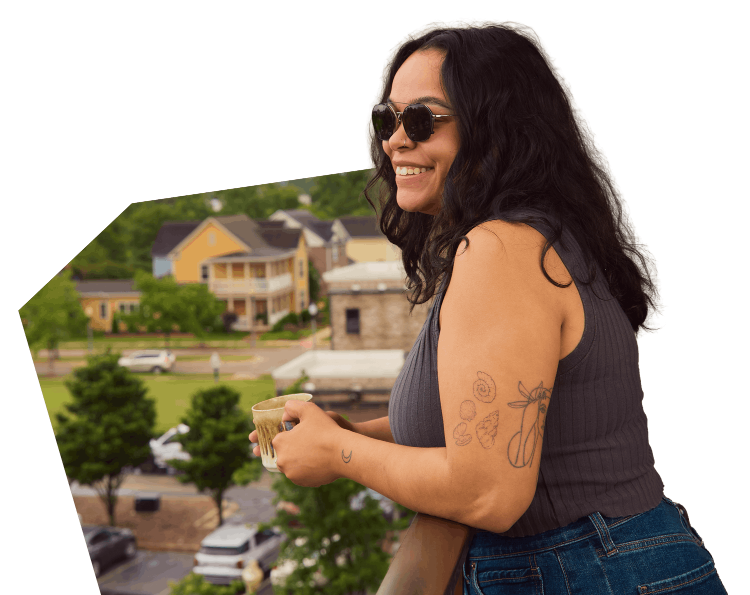 smiling girl drinking coffee on her apartment balcony in downtown Tupelo, MS.