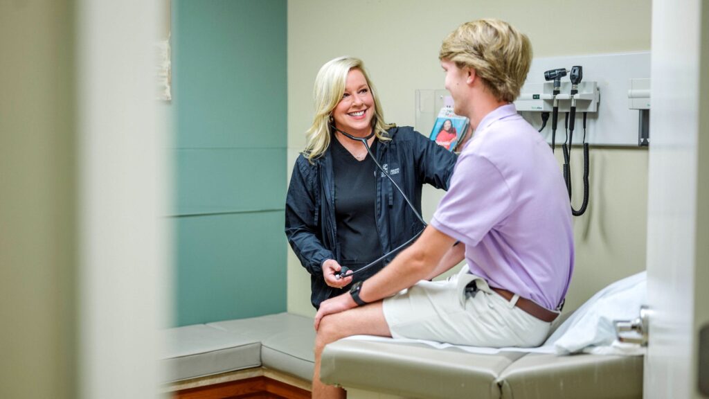 Smiling doctor taking the blood pressure of a patient at a routine checkup.